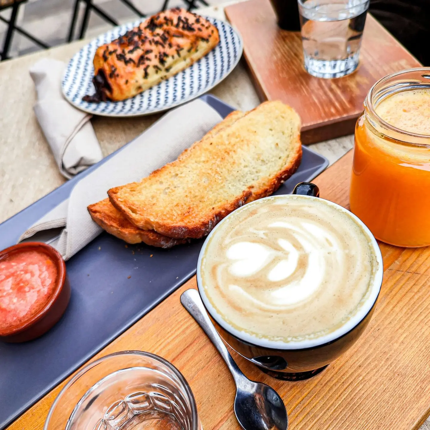 a wooden table topped with plates of food and drinks